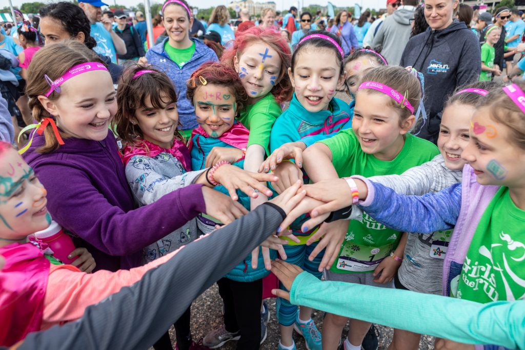 Girls on the Run participants huddle for a cheer before the organization’s annual 5K. (Courtesy Rebecca Studios)