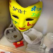 a yellow mask on a shelft with the words "smart, strong" and other illegible words on it. 