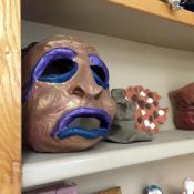 a brown and purple mask sitting on a shelf