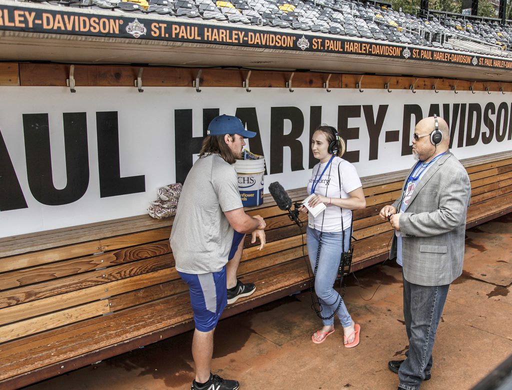 Minneapolis Roosevelt student Talia Bradley (center) interviews a St. Paul Saints player (left) with her mentor, Jonathan Blakely, MPR news program director, during ThreeSixty's Broadcast Radio Camp in July at CHS Field. (Photo courtesy of Maria Alejandra Cardona, MPR News)